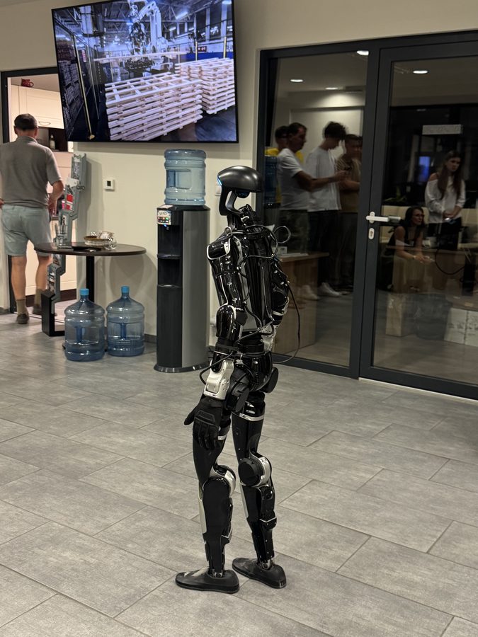 Humanoid robot welcoming guests at the reception of a corporate event in a modern interior